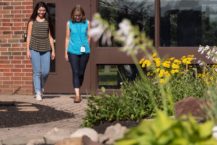 Two women walking on the Villa of Hope campus